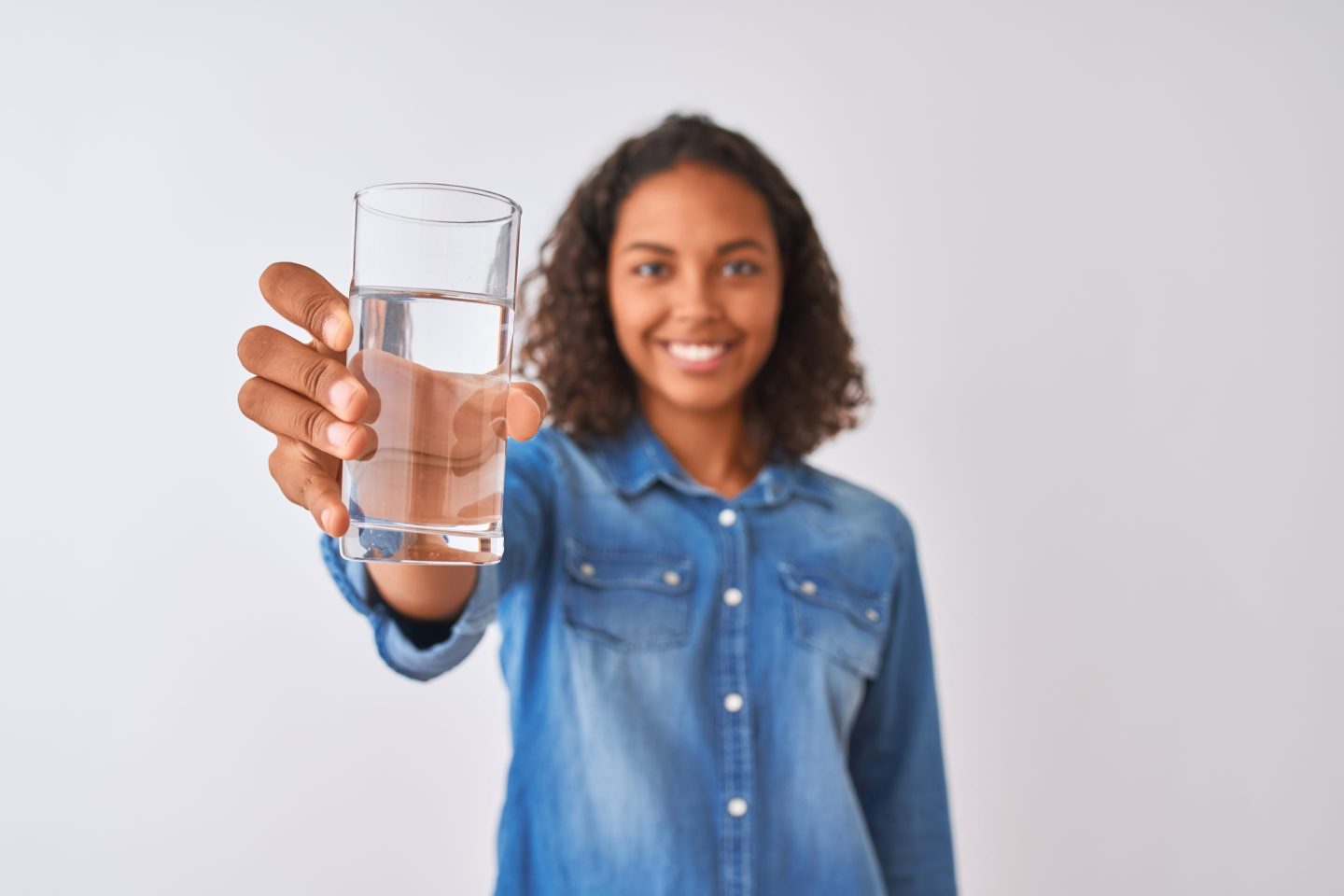 Woman holding glass of water and smiling