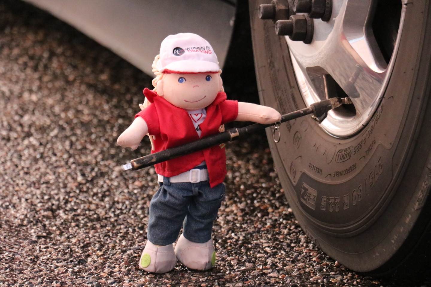 Clare doll checking the tire pressure of a truck.